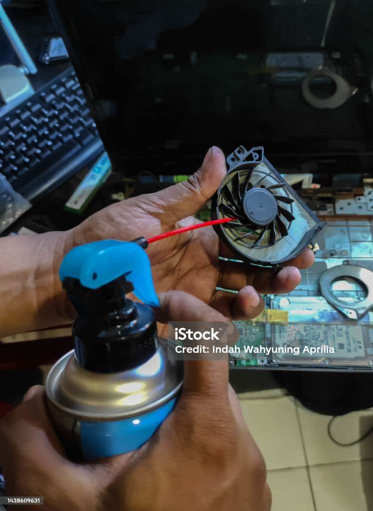 holding fan blade while cleaning with compressed air