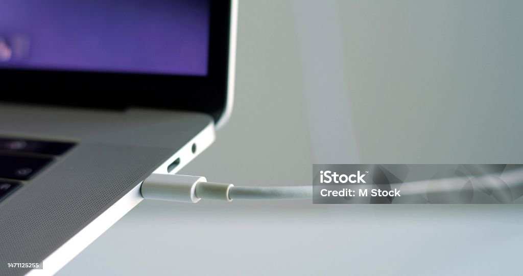 student connecting USB-C cable to laptop