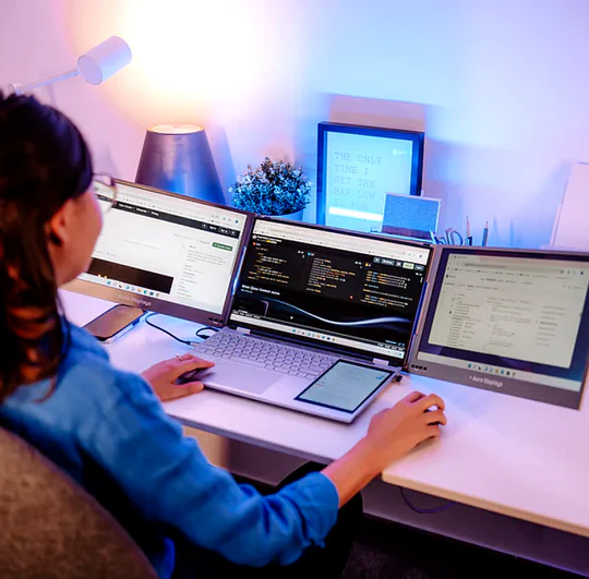 student writing essay dual screen laptop portable monitor setup